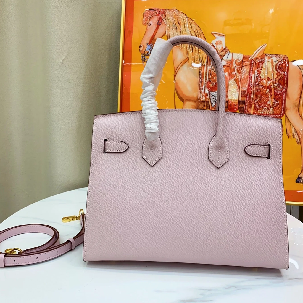 Delicate Pale Blush Pink Fine Grain Sharp Contour Compact Trapezoid Tote With Warm Golden Twist Lock Hardware And Matching Coordinating Carry Strap Leather